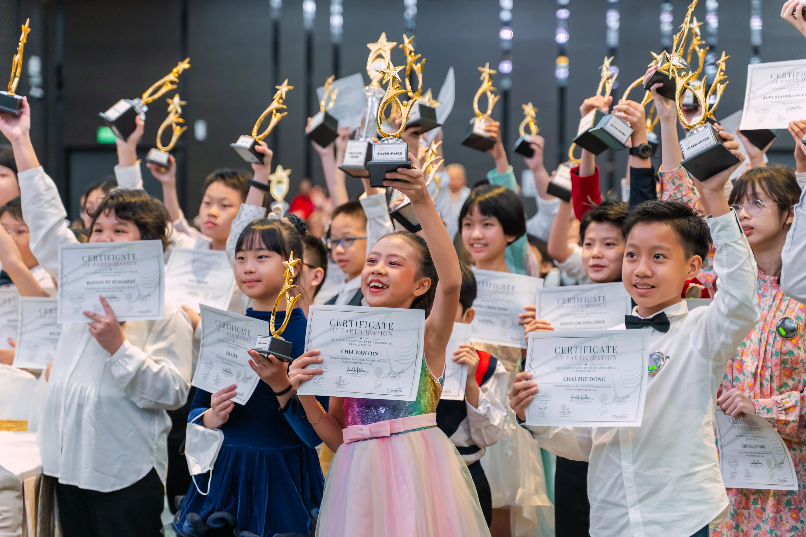 Young Gold Star Music Festival participants celebrate with trophies and certificates