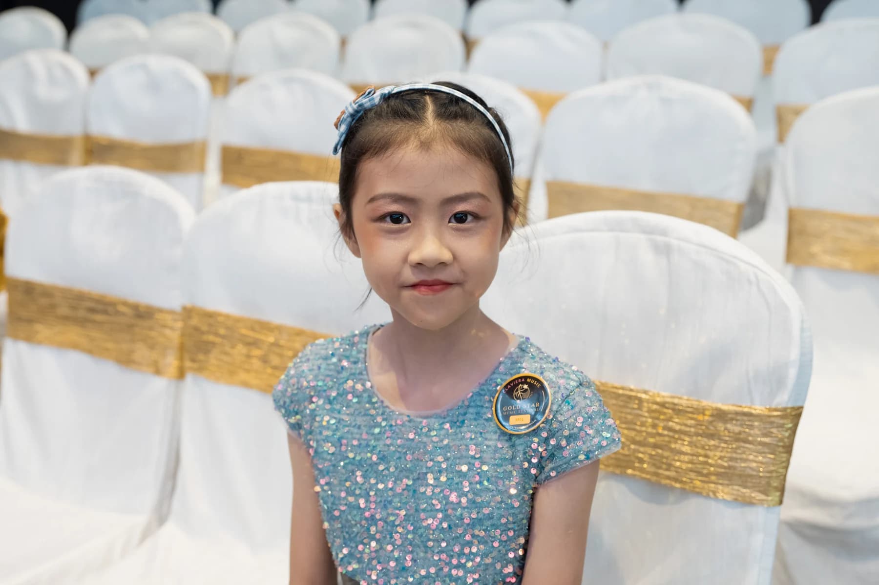 A young Gold Star Music Festival 2023 participant waits in the audience